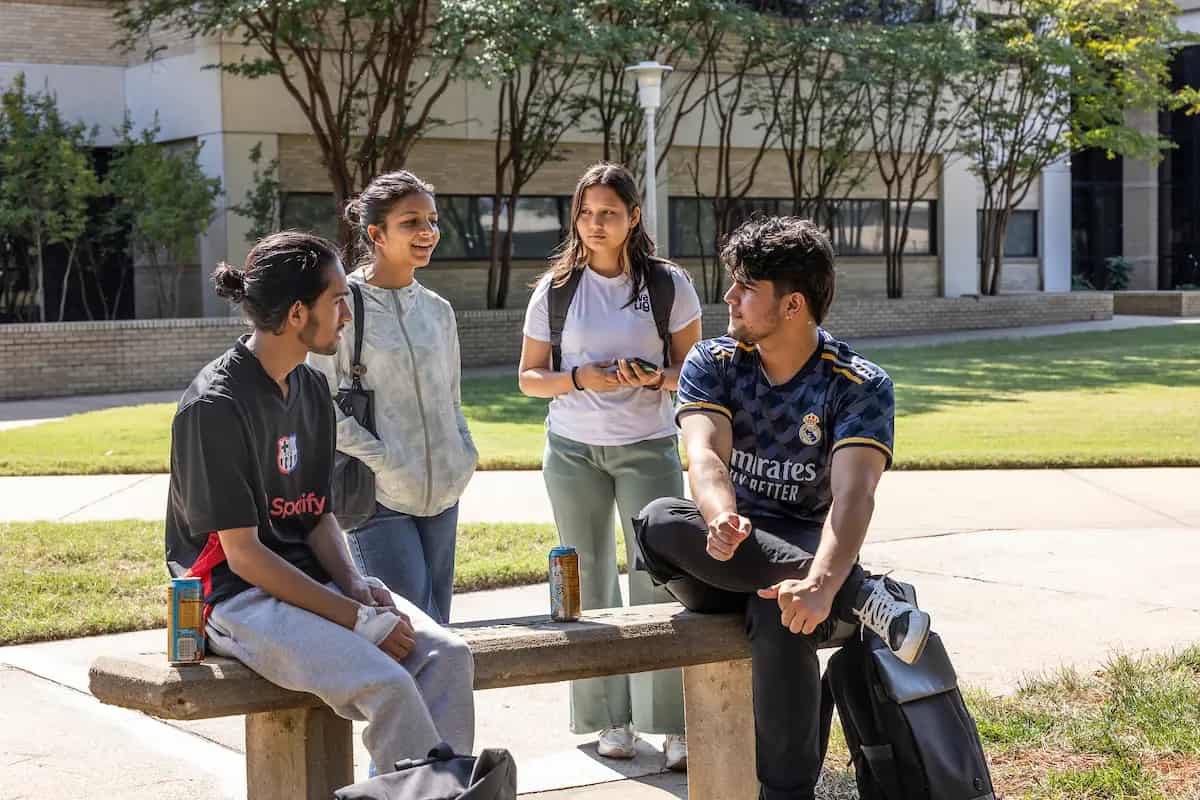 Students talking on a bench on the A-State campus