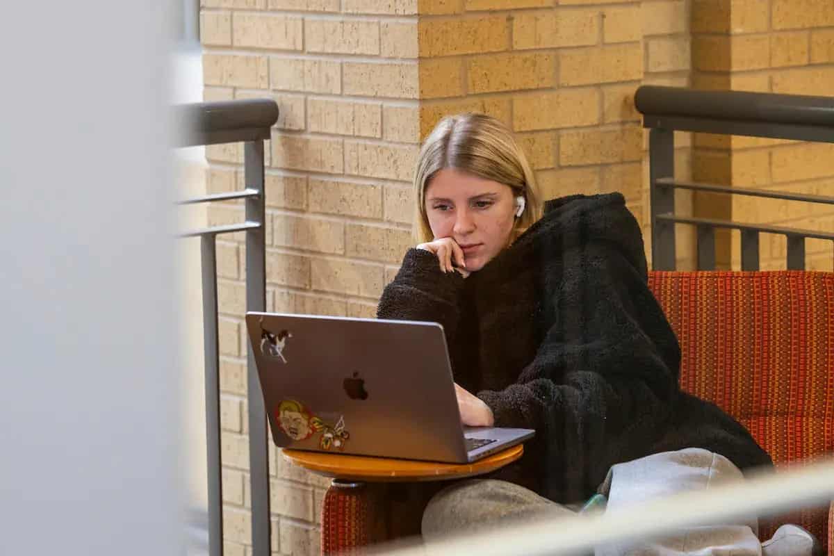 An A-State student studying on a laptop indoors