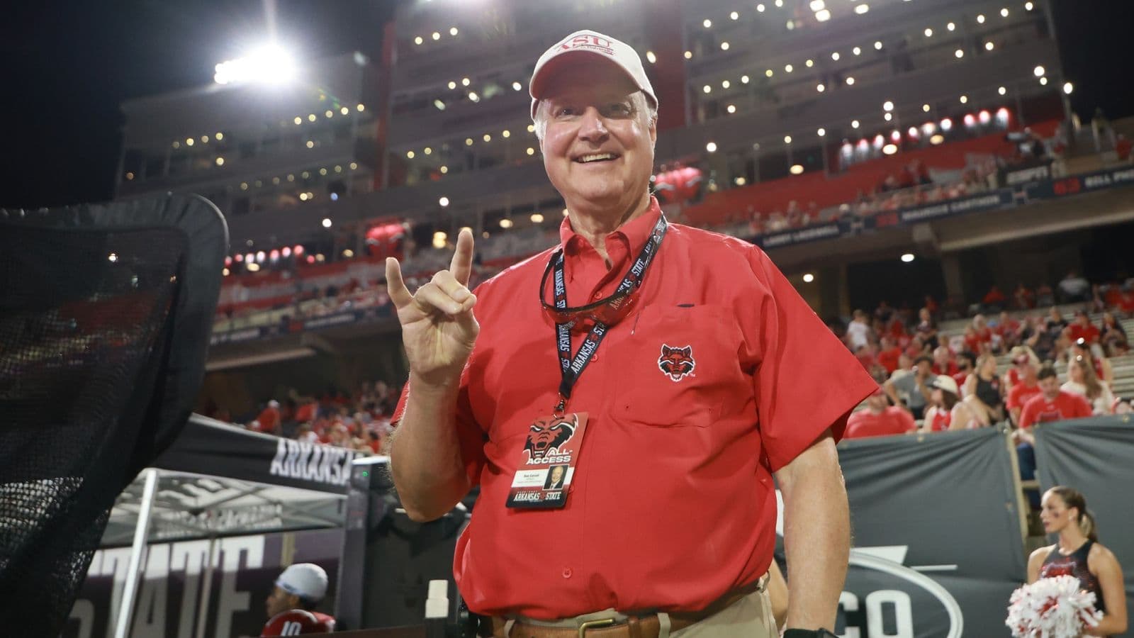 Ron Carroll giơ tay chào kiểu “Wolves Up” bên đường biên sân bóng bầu dục của A-State