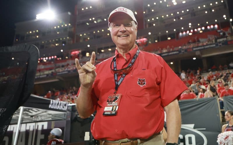 Ron Carroll giơ tay chào kiểu “Wolves Up” bên đường biên sân bóng bầu dục của A-State